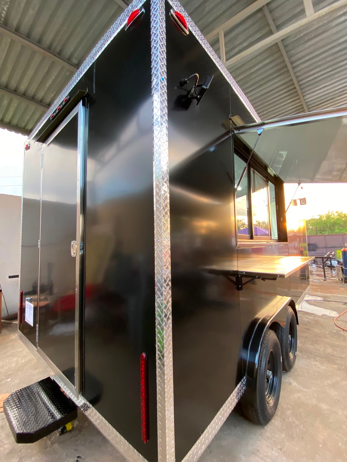 Rear three-quarter view showing the double rear doors, diamond-plate step and marker lights.